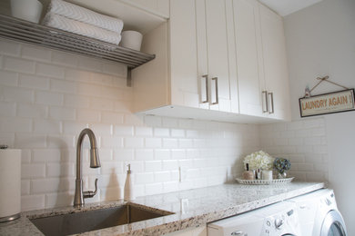 Inspiration for a timeless single-wall laundry room remodel in Toronto with flat-panel cabinets, white cabinets and white walls