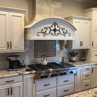 This is an example of an expansive victorian u-shaped kitchen pantry in Other with an undermount sink, raised-panel cabinets, white cabinets, granite benchtops, white splashback, stainless steel appliances and multiple islands.