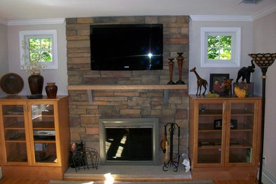 Family room - mid-sized transitional open concept medium tone wood floor and brown floor family room idea in New York with beige walls, a standard fireplace, a stone fireplace and a wall-mounted tv