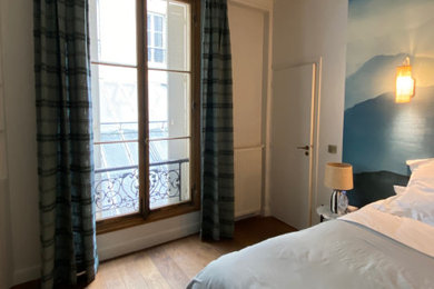 Imagen de dormitorio principal clásico renovado de tamaño medio con paredes blancas, suelo de madera clara y suelo marrón