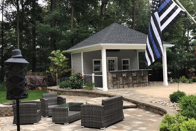 Inspiration for a large transitional backyard stone patio kitchen remodel in New York with a gazebo