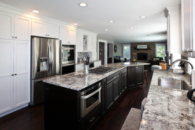 Kitchen - large transitional galley dark wood floor and brown floor kitchen idea in Chicago with an undermount sink, stainless steel appliances, recessed-panel cabinets, white cabinets, granite countertops, multicolored backsplash, glass tile backsplash and an island