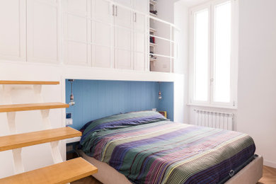 Ejemplo de dormitorio principal actual pequeño con paredes blancas, suelo de madera clara y machihembrado