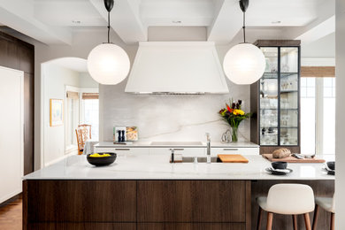 Inspiration for a mid-sized modern medium tone wood floor, brown floor and coffered ceiling eat-in kitchen remodel in Calgary with an undermount sink, flat-panel cabinets, white cabinets, quartzite countertops, white backsplash, stone slab backsplash, stainless steel appliances, an island and white countertops