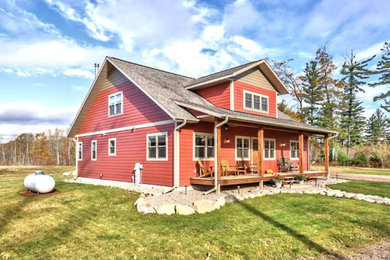 Cottage red two-story clapboard exterior home idea in Other with a shingle roof and a gray roof