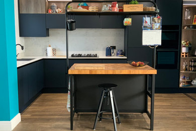 Photo of a medium sized modern l-shaped kitchen/diner with flat-panel cabinets, blue cabinets, quartz worktops, white splashback, engineered quartz splashback, integrated appliances, an island and white worktops.