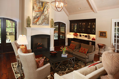 Photo of a mid-sized traditional formal enclosed living room in Atlanta with beige walls, medium hardwood floors, a standard fireplace, a concrete fireplace surround and no tv.