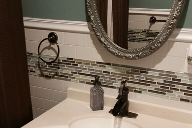 Bathroom - small contemporary 3/4 white tile light wood floor bathroom idea in New York with an integrated sink, recessed-panel cabinets, dark wood cabinets, quartz countertops, a one-piece toilet and blue walls