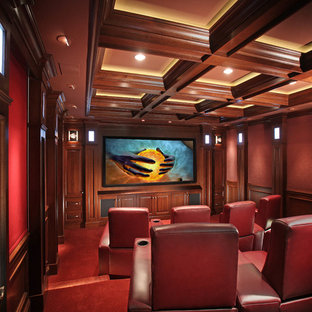 Idées déco pour une salle de cinéma classique fermée avec un mur rouge, moquette, un téléviseur fixé au mur et un sol rouge.