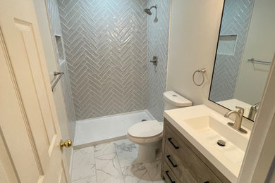 Mid-sized minimalist 3/4 gray tile and subway tile porcelain tile, white floor and single-sink wet room photo in DC Metro with flat-panel cabinets, medium tone wood cabinets, white walls, an integrated sink, solid surface countertops, white countertops and a freestanding vanity