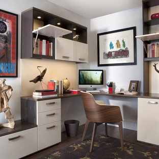 Medium sized modern study in New York with white walls, dark hardwood flooring, no fireplace and a built-in desk.