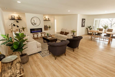 Photo of a mid-sized contemporary formal open concept living room in San Luis Obispo with beige walls, light hardwood floors, a ribbon fireplace, a plaster fireplace surround, no tv and beige floor.