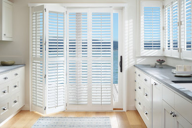Inspiration for a mid-sized coastal galley medium tone wood floor kitchen remodel in New York with an undermount sink, shaker cabinets, white cabinets, concrete countertops and no island