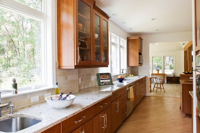 Mid-sized elegant l-shaped medium tone wood floor and brown floor open concept kitchen photo in Baltimore with an undermount sink, flat-panel cabinets, medium tone wood cabinets, wood countertops, beige backsplash, stone tile backsplash, stainless steel appliances and an island