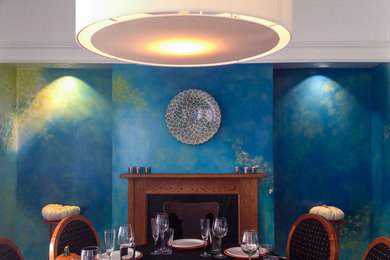 Example of a mid-sized minimalist dark wood floor enclosed dining room design in Chicago with blue walls, a standard fireplace and a wood fireplace surround