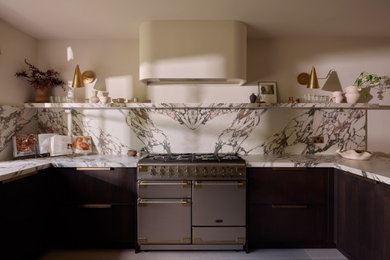 Medium sized modern u-shaped kitchen/diner in London with a submerged sink, shaker cabinets, dark wood cabinets, engineered stone countertops, stainless steel appliances and grey floors.