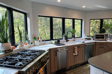 Eat-in kitchen - large u-shaped porcelain tile and gray floor eat-in kitchen idea in Boston with an undermount sink, shaker cabinets, medium tone wood cabinets, quartz countertops, white backsplash, quartz backsplash, stainless steel appliances, an island and white countertops