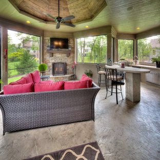 Mediterraner Wintergarten mit Kaminsims aus Stein, normaler Decke, Betonboden und grauem Boden in Kansas City