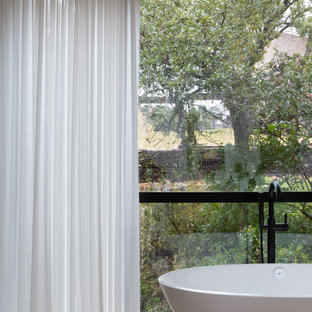 Example of a large minimalist master gray tile and mosaic tile limestone floor and beige floor freestanding bathtub design in Austin with flat-panel cabinets, light wood cabinets, beige walls, an undermount sink, quartzite countertops and white countertops