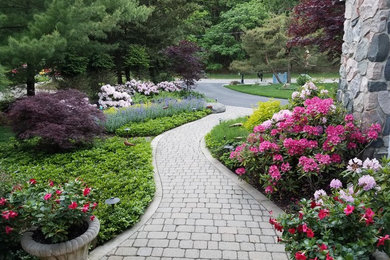 Design ideas for a mid-sized traditional front yard partial sun driveway for summer in Grand Rapids with a garden path and brick pavers.