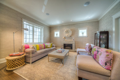 Living room - mid-sized transitional enclosed medium tone wood floor living room idea in Toronto with beige walls, a standard fireplace, a stone fireplace and no tv