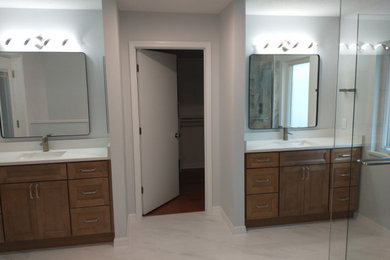 Corner shower - large traditional master multicolored tile and porcelain tile porcelain tile, multicolored floor and double-sink corner shower idea in Orlando with recessed-panel cabinets, medium tone wood cabinets, quartz countertops, white countertops and a built-in vanity