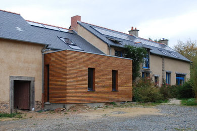 Cette image montre une grande façade de maison beige design en adobe à deux étages et plus avec un toit à deux pans et un toit mixte.