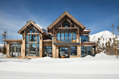 Inspiration for a huge rustic beige two-story gable roof remodel in Other