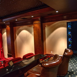 Large elegant enclosed carpeted and black floor home theater photo in Charleston with beige walls and a media wall