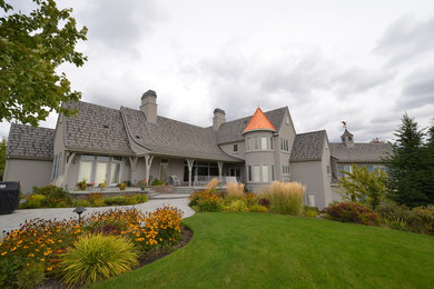 Large elegant beige two-story stucco gable roof photo in Seattle