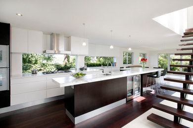 Photo of a large modern single-wall eat-in kitchen in Sydney with flat-panel cabinets, marble benchtops, stainless steel appliances, a single-bowl sink, white cabinets, glass sheet splashback, dark hardwood floors and with island.