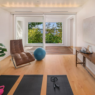 シアトルのビーチスタイルのおしゃれなヨガスタジオ (白い壁、無垢フローリング、茶色い床) の写真