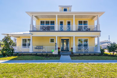 Example of a large transitional yellow two-story stucco house exterior design in Other with a metal roof