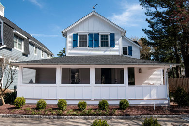 Ejemplo de fachada de casa blanca y gris costera grande de dos plantas con revestimiento de aglomerado de cemento, tejado a dos aguas, tejado de teja de madera y tablilla