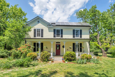 Farmhouse yellow house exterior idea in Other