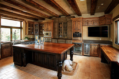 Large mountain style u-shaped kitchen pantry photo in Kansas City with a farmhouse sink, medium tone wood cabinets, stainless steel appliances and an island