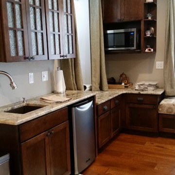 Cabinets.com | Unique Kitchen with Dark Stained Cabinetry and Bench Seating