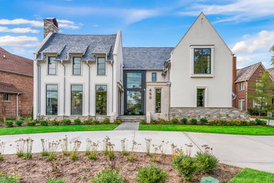 Example of a large transitional white three-story stucco exterior home design in Chicago with a shingle roof and a gray roof