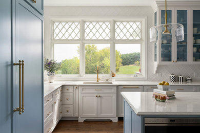 Eat-in kitchen - large transitional u-shaped medium tone wood floor and brown floor eat-in kitchen idea in Columbus with an undermount sink, shaker cabinets, blue cabinets, quartz countertops, white backsplash, porcelain backsplash, paneled appliances, an island and white countertops