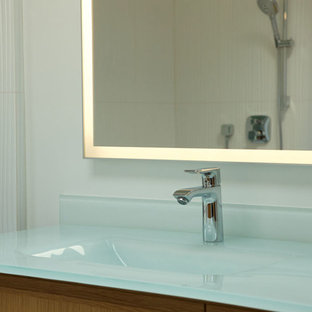 Inspiration for a large contemporary master white tile and ceramic tile ceramic floor and white floor bathroom remodel in San Francisco with flat-panel cabinets, light wood cabinets, a one-piece toilet, white walls, an integrated sink, recycled glass countertops and white countertops