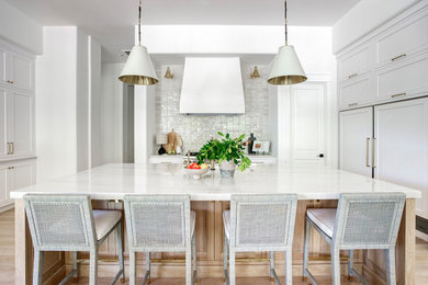 Large transitional u-shaped light wood floor kitchen pantry photo in Phoenix with beaded inset cabinets, quartzite countertops, white backsplash, stone tile backsplash, an island and white countertops