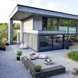 Inspiration för ett stort funkis grått hus, med två våningar, platt tak och tak i metall