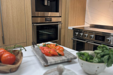Inspiration for a transitional kitchen remodel with light wood cabinets, stainless steel appliances and white countertops