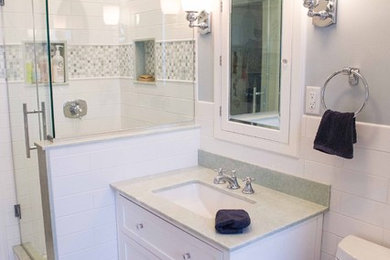Small transitional kids' multicolored tile and mosaic tile mosaic tile floor corner shower photo in New York with shaker cabinets, white cabinets, a one-piece toilet, gray walls, an undermount sink and quartzite countertops