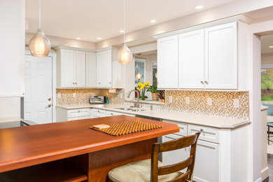 Example of a mid-sized transitional l-shaped dark wood floor enclosed kitchen design in Detroit with an undermount sink, flat-panel cabinets, white cabinets, quartz countertops, multicolored backsplash, stone tile backsplash and stainless steel appliances