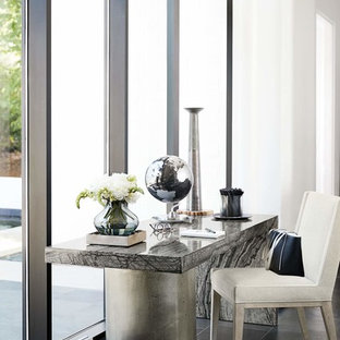 Foto på ett mellanstort funkis hemmabibliotek, med vita väggar, skiffergolv, ett fristående skrivbord och svart golv