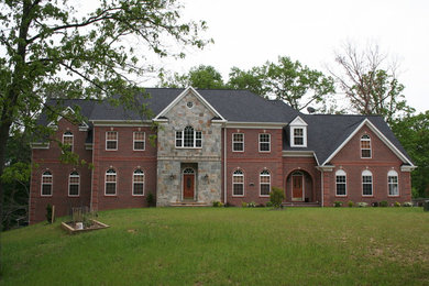 Large elegant red two-story brick exterior home photo in DC Metro