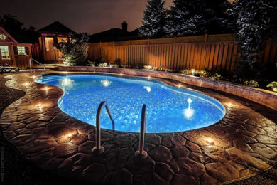 Pool - mid-sized contemporary backyard stamped concrete and custom-shaped pool idea in Toronto