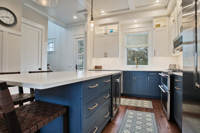 This is an example of a mid-sized beach style l-shaped eat-in kitchen in Other with an undermount sink, shaker cabinets, blue cabinets, quartz benchtops, white splashback, engineered quartz splashback, stainless steel appliances, medium hardwood floors, with island, white benchtop and coffered.