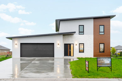 Modern white two-story stucco house exterior idea in Other with a metal roof